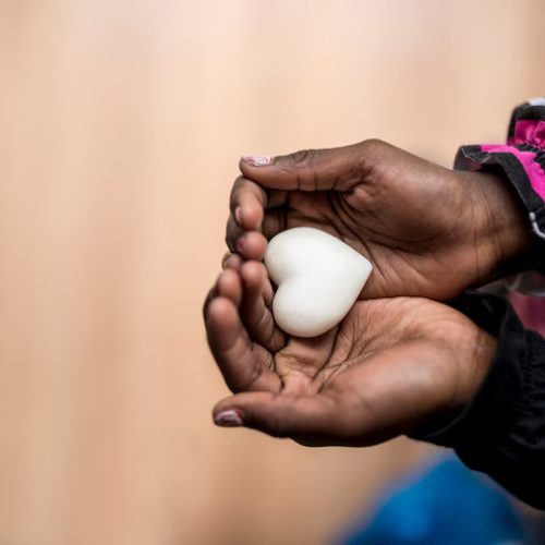 closeup-african-american-girl-holding-marble-made-heart-shape-her-hands_254268-625