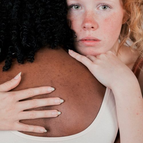 portrait-caucasian-young-woman-hugging-african-female_23-2148178710